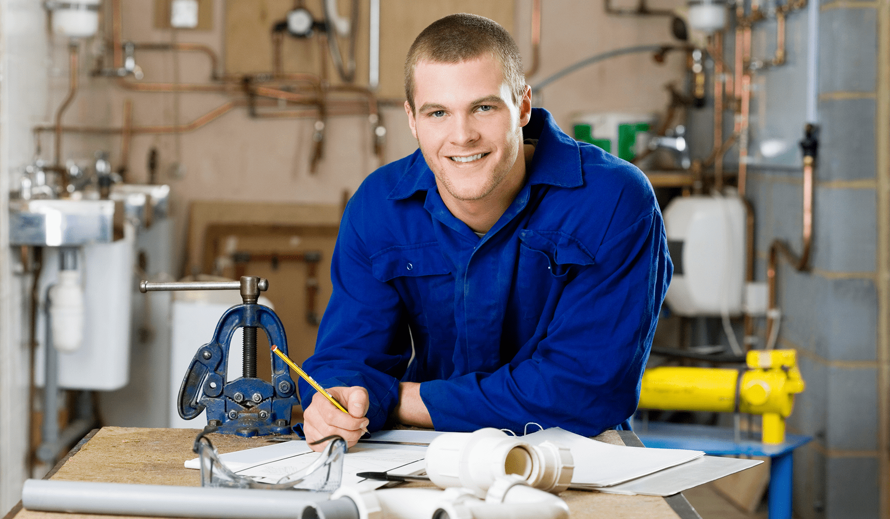 Plumber working with pipes in workshop.