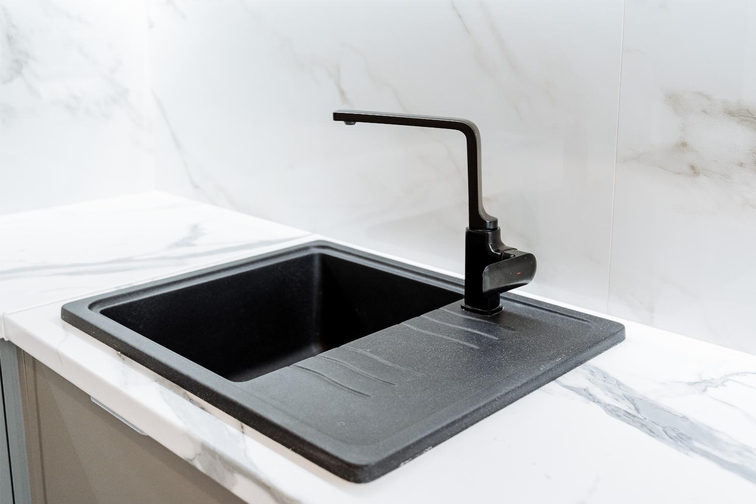 Sleek black sink on marble countertop