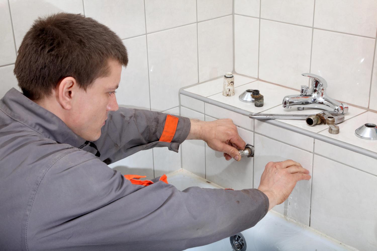 Technician adjusting bathroom plumbing