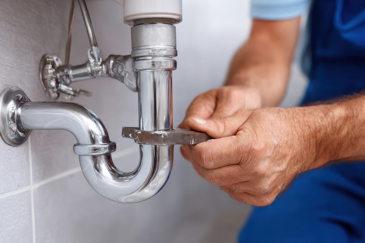 Plumber fixing a bathroom sink pipe