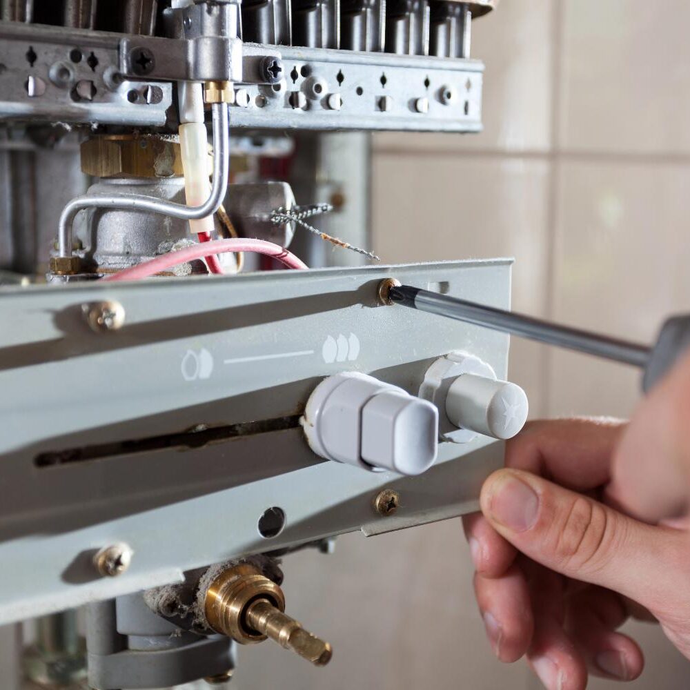Hand using screwdriver on appliance